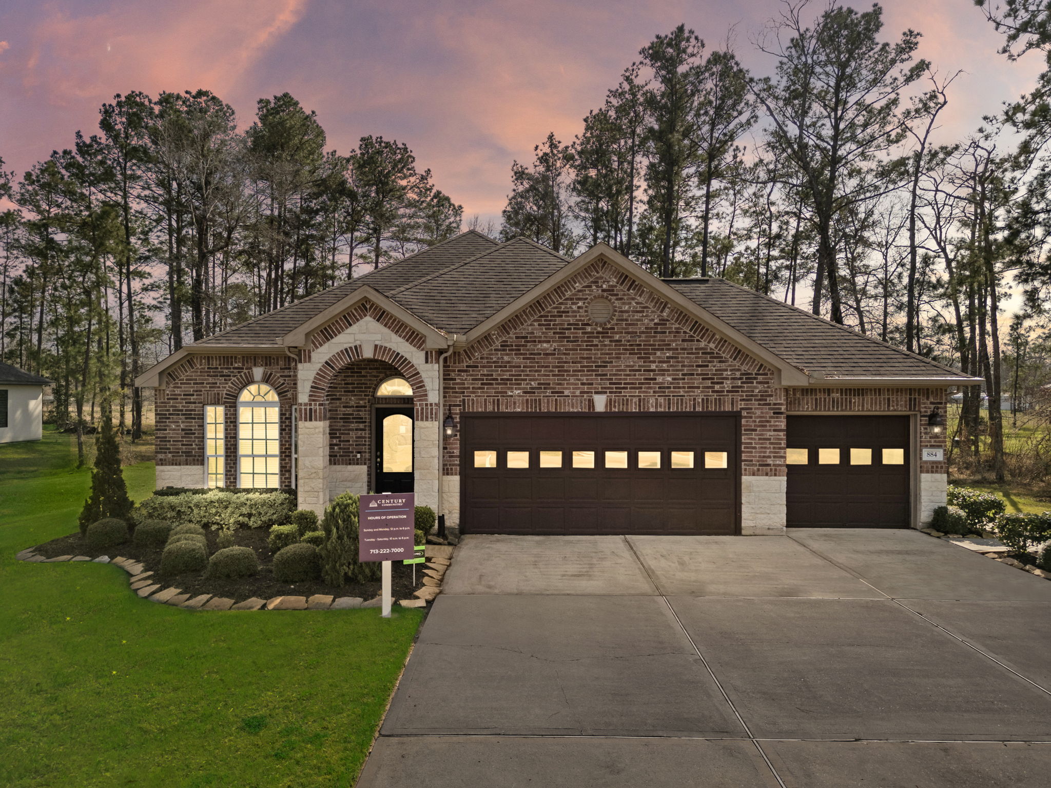 A house with a driveway and a sign in front of it.