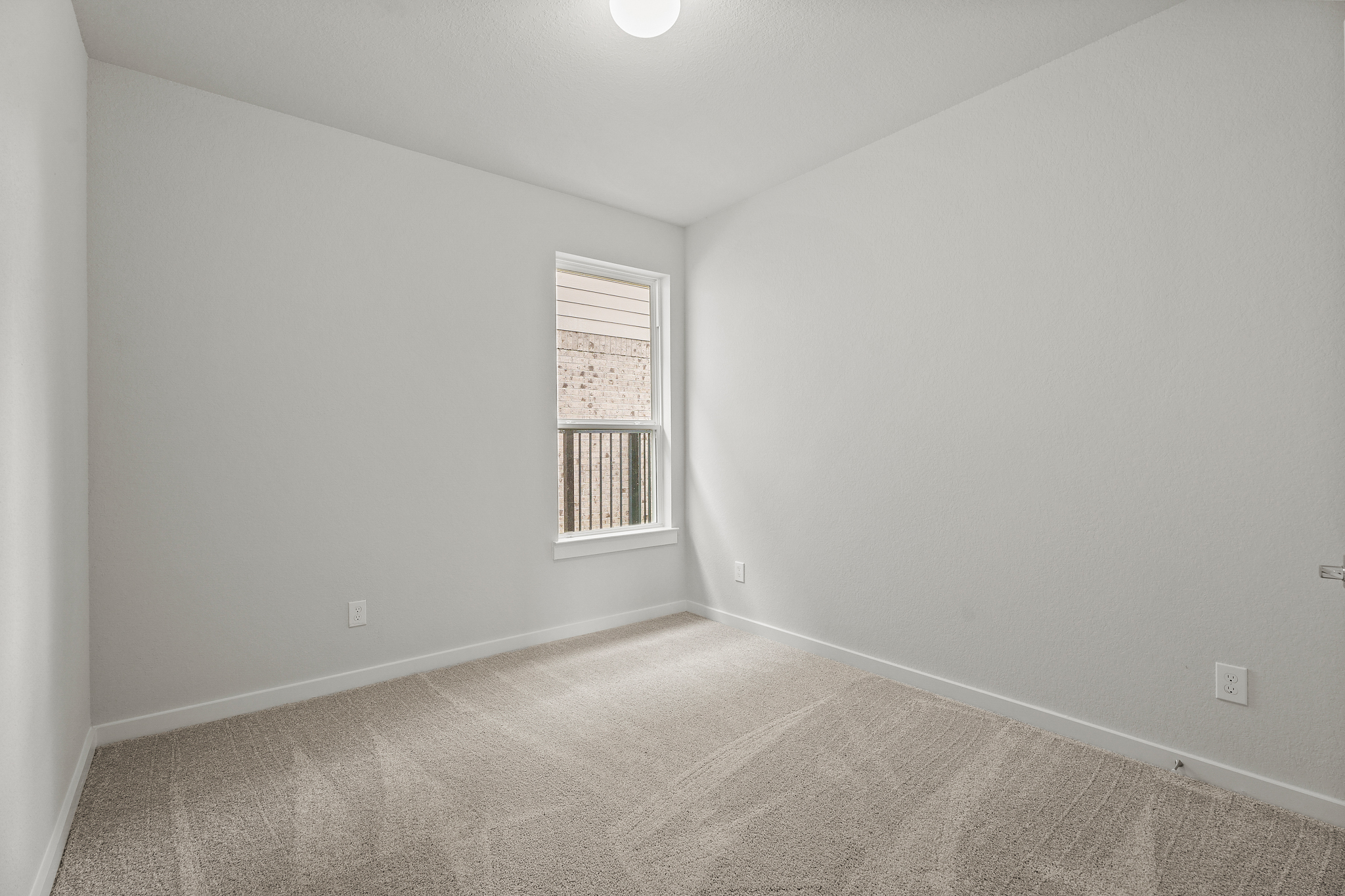 A room with a window and carpet.