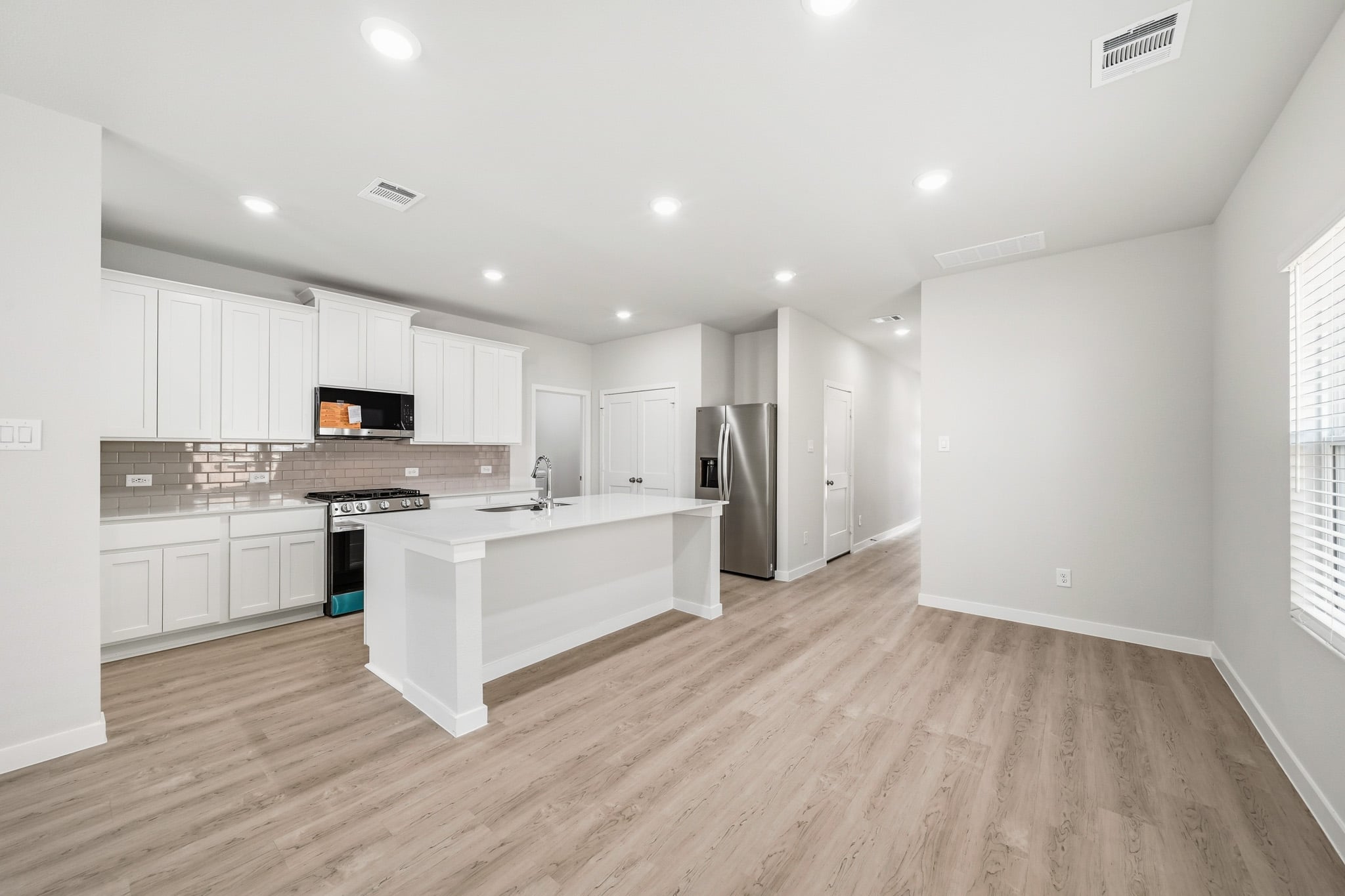 A kitchen with white cabinets.