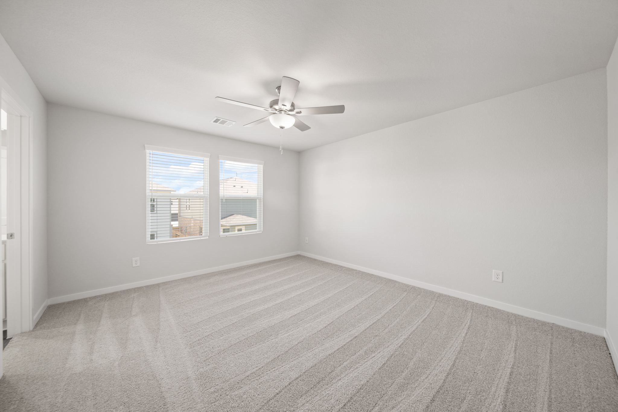 A room with a ceiling fan and a wood floor.