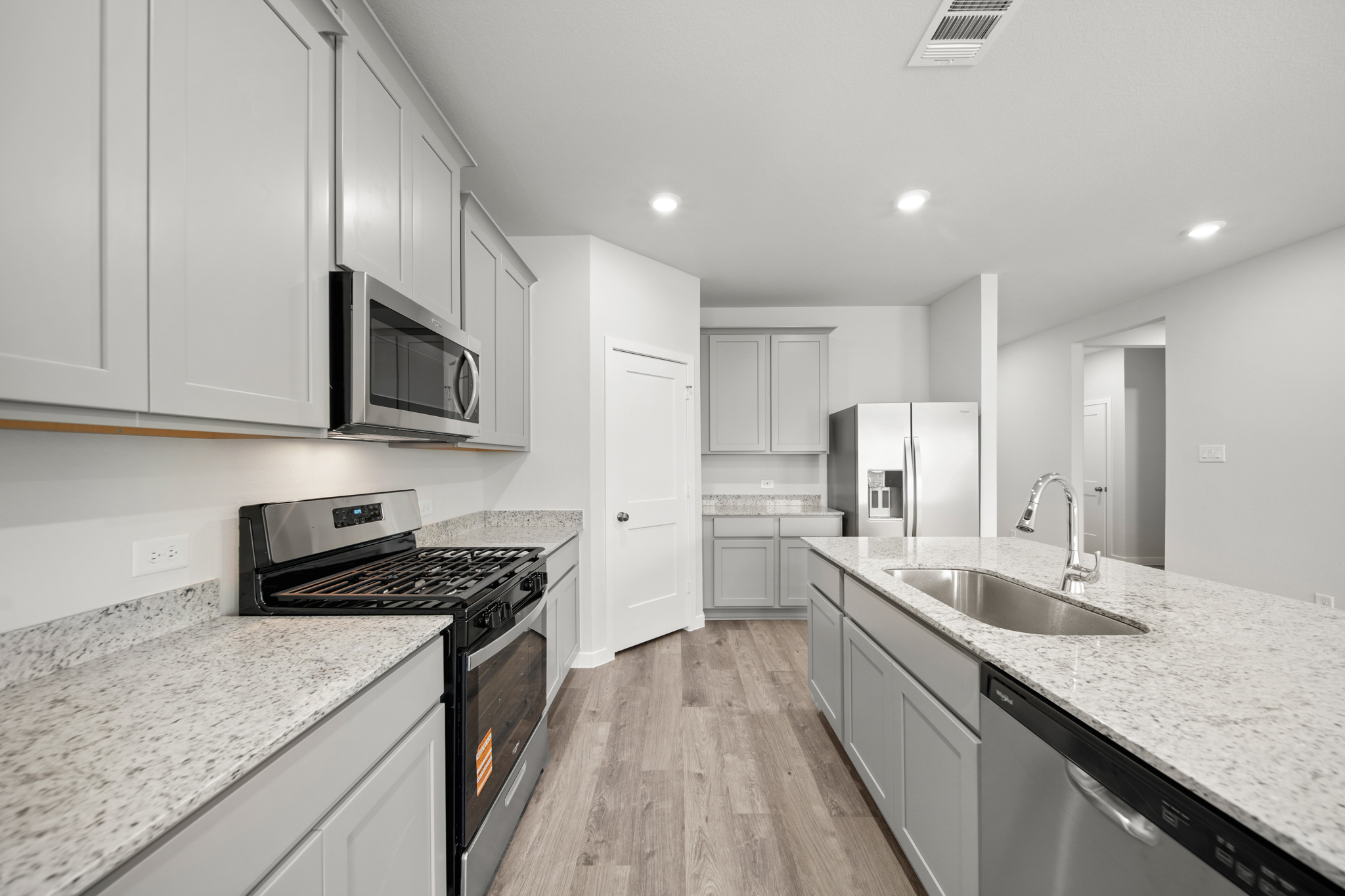 A kitchen with white cabinets.