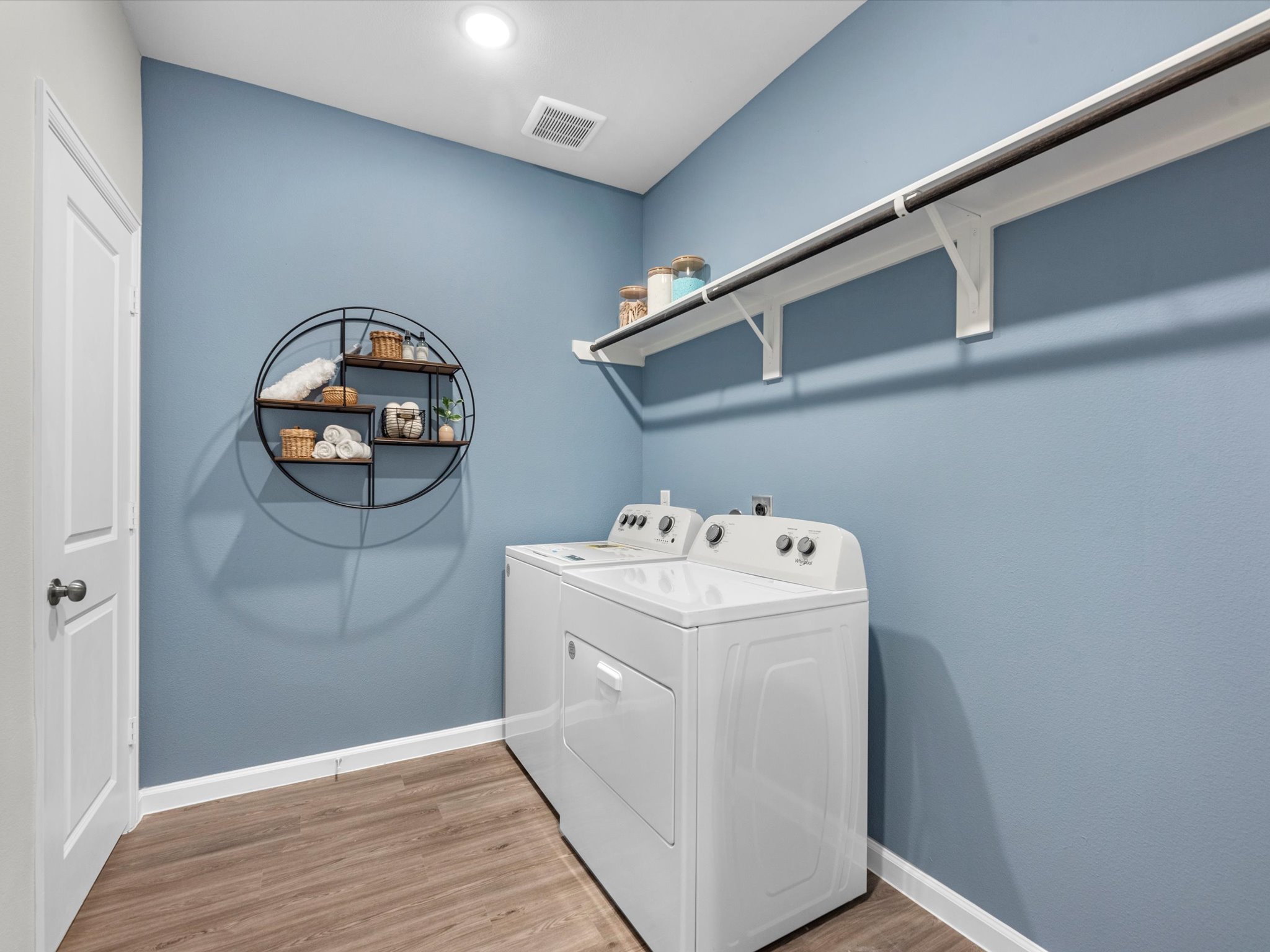 A laundry room with a white shelf.