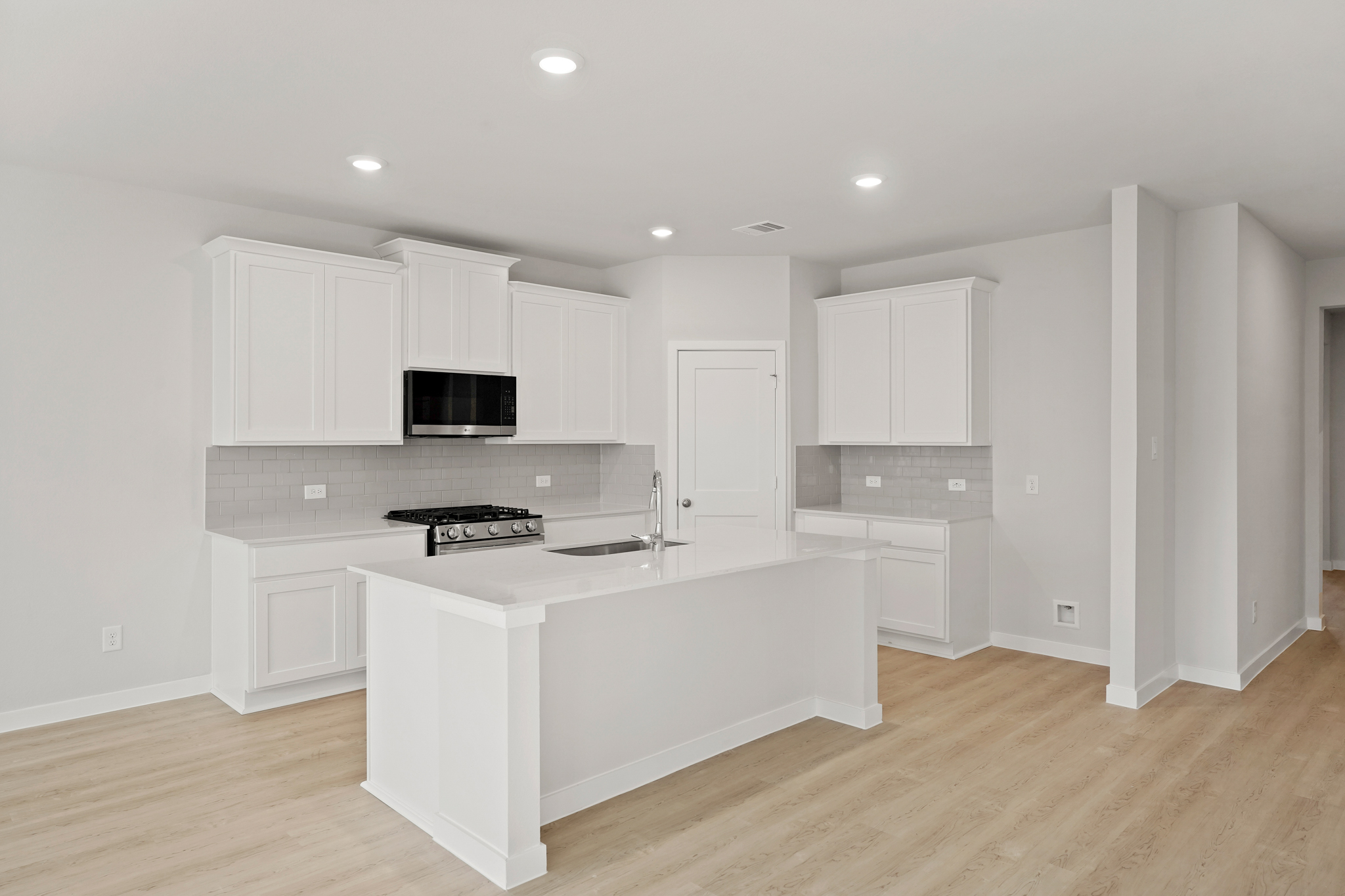 A kitchen with white cabinets.