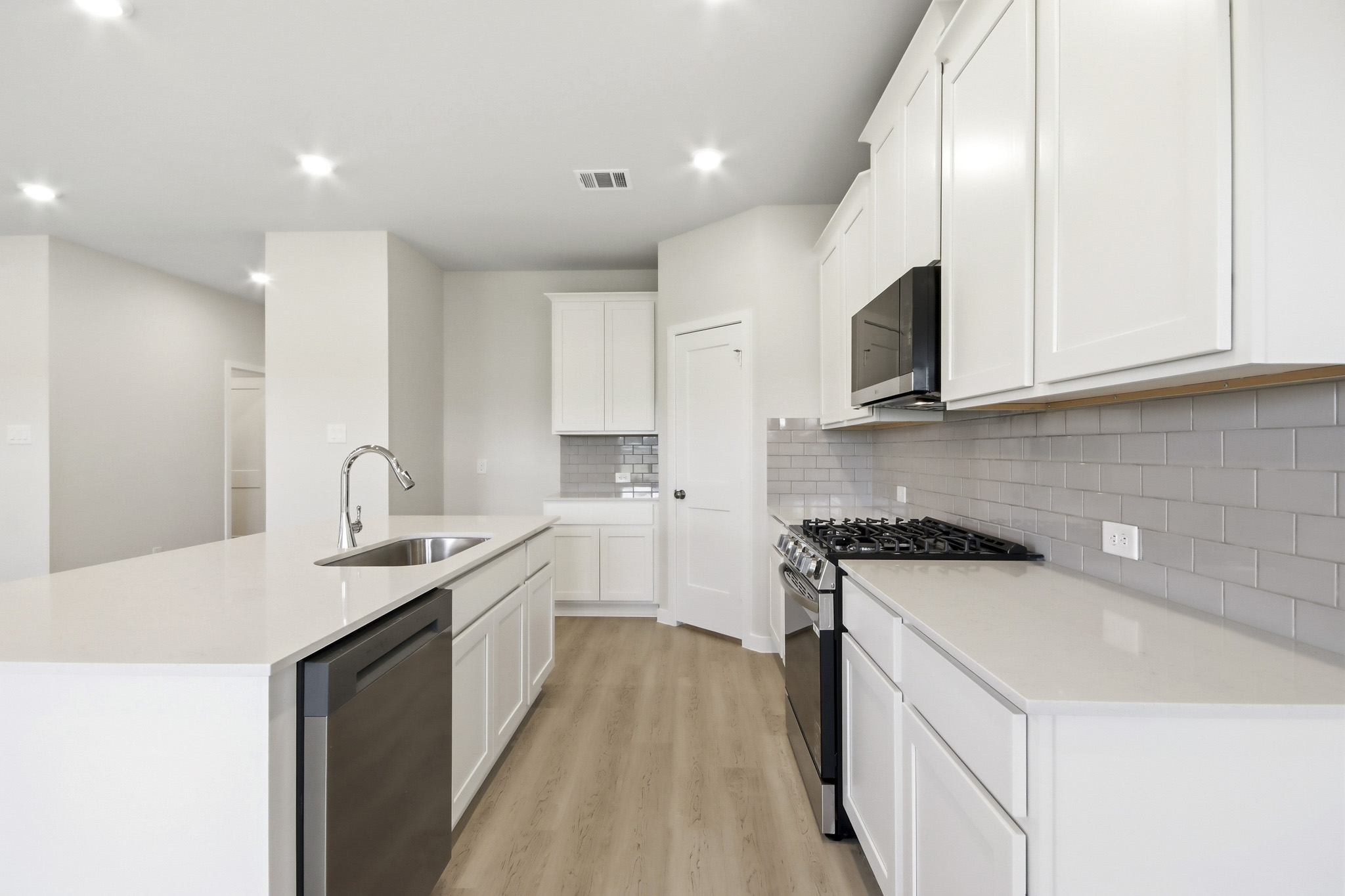 A kitchen with white cabinets.