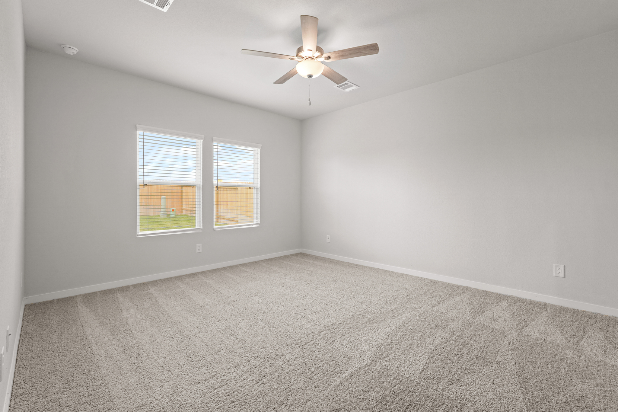 A room with a ceiling fan and a window.