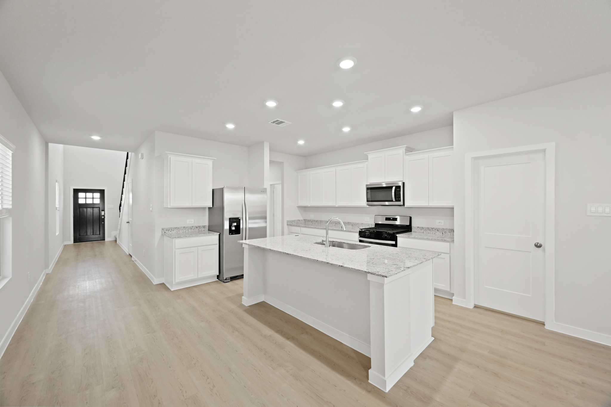 A kitchen with white cabinets.