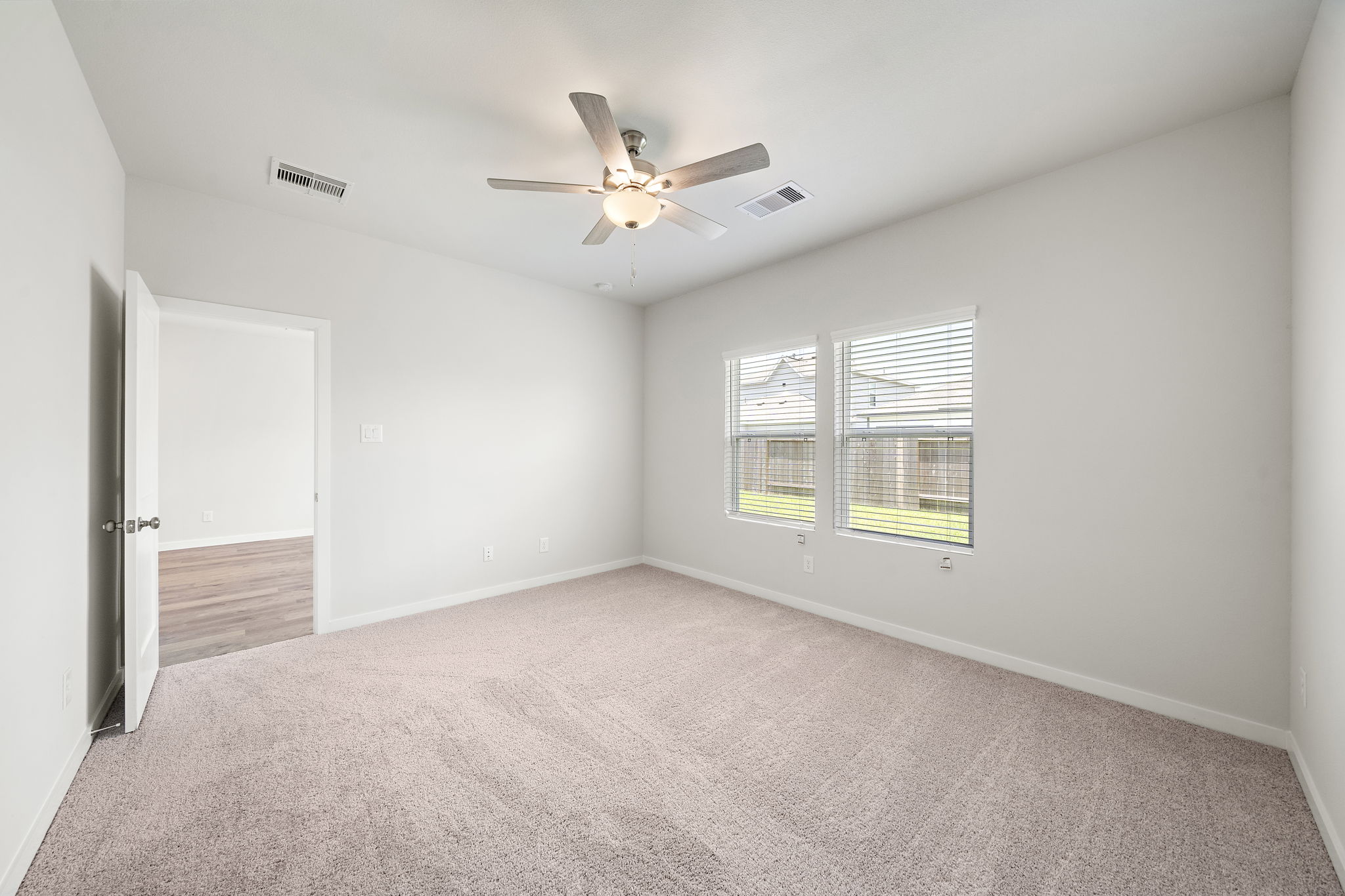 A room with a ceiling fan and a window.