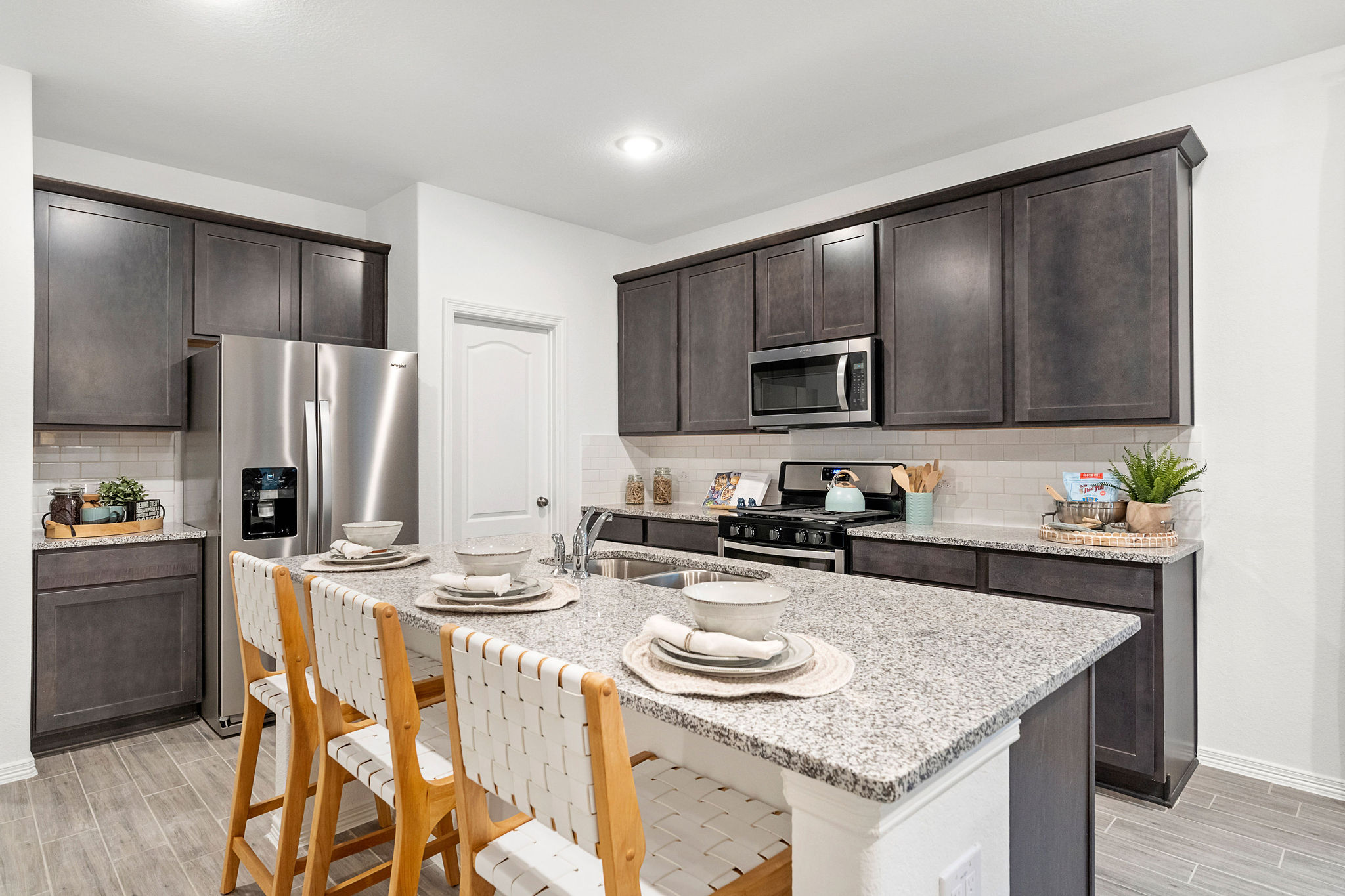 A kitchen with a table and chairs.