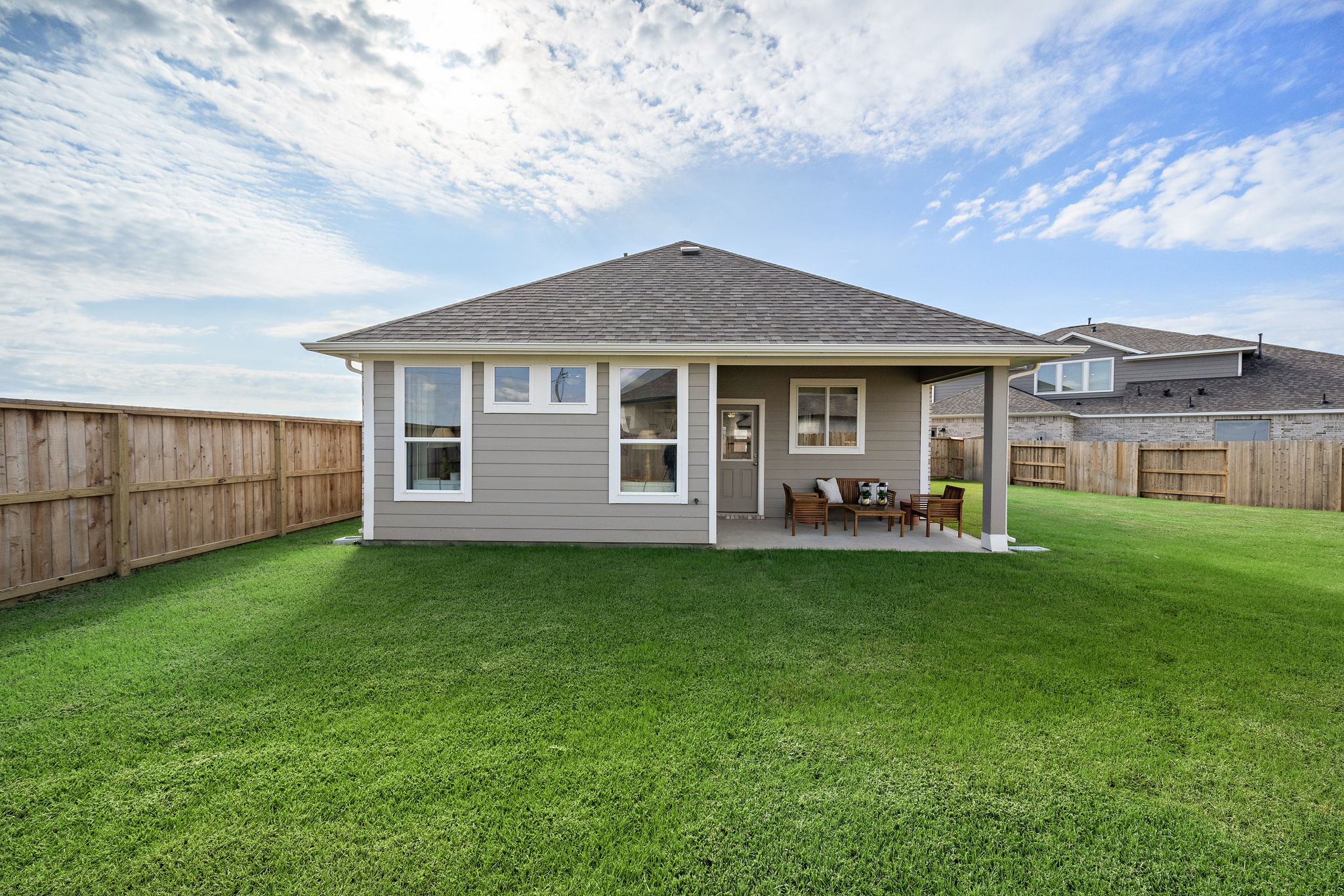 A house with a lawn and chairs.
