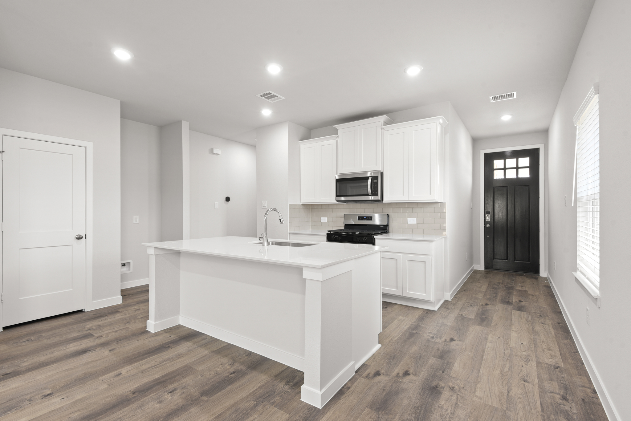 A kitchen with white cabinets.