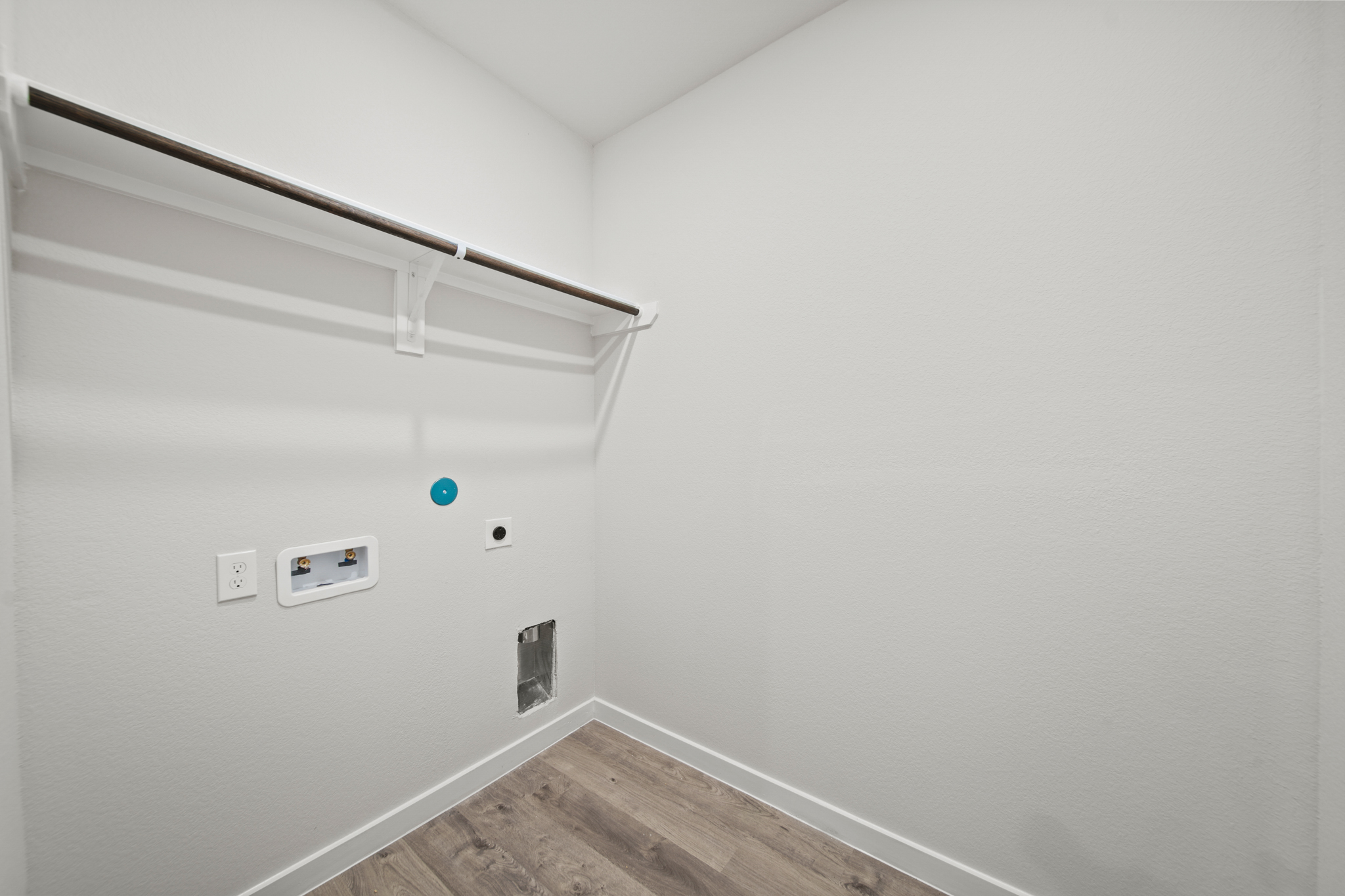 A white wall with a wood floor.