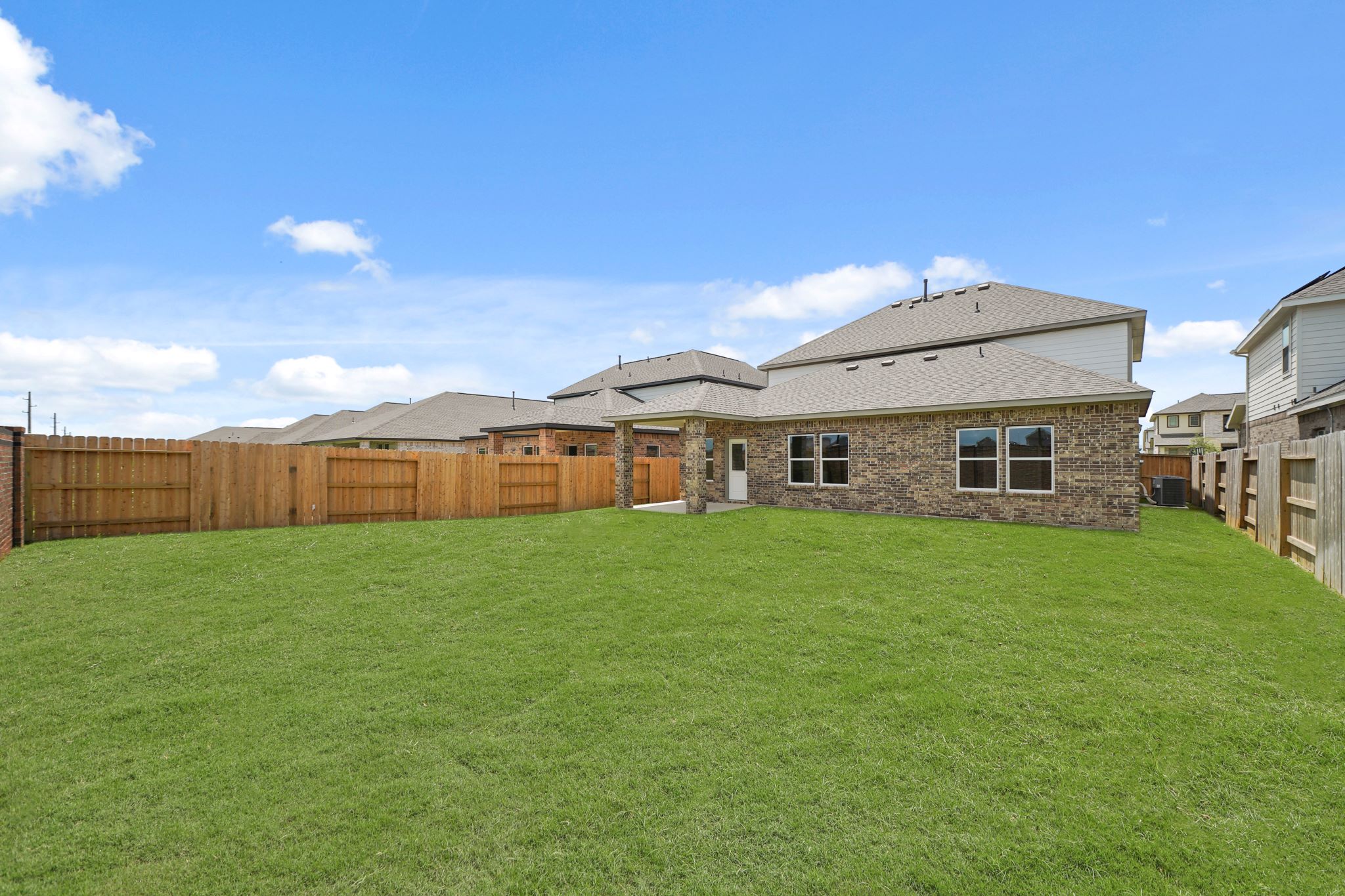 A large green field with a building in the background.