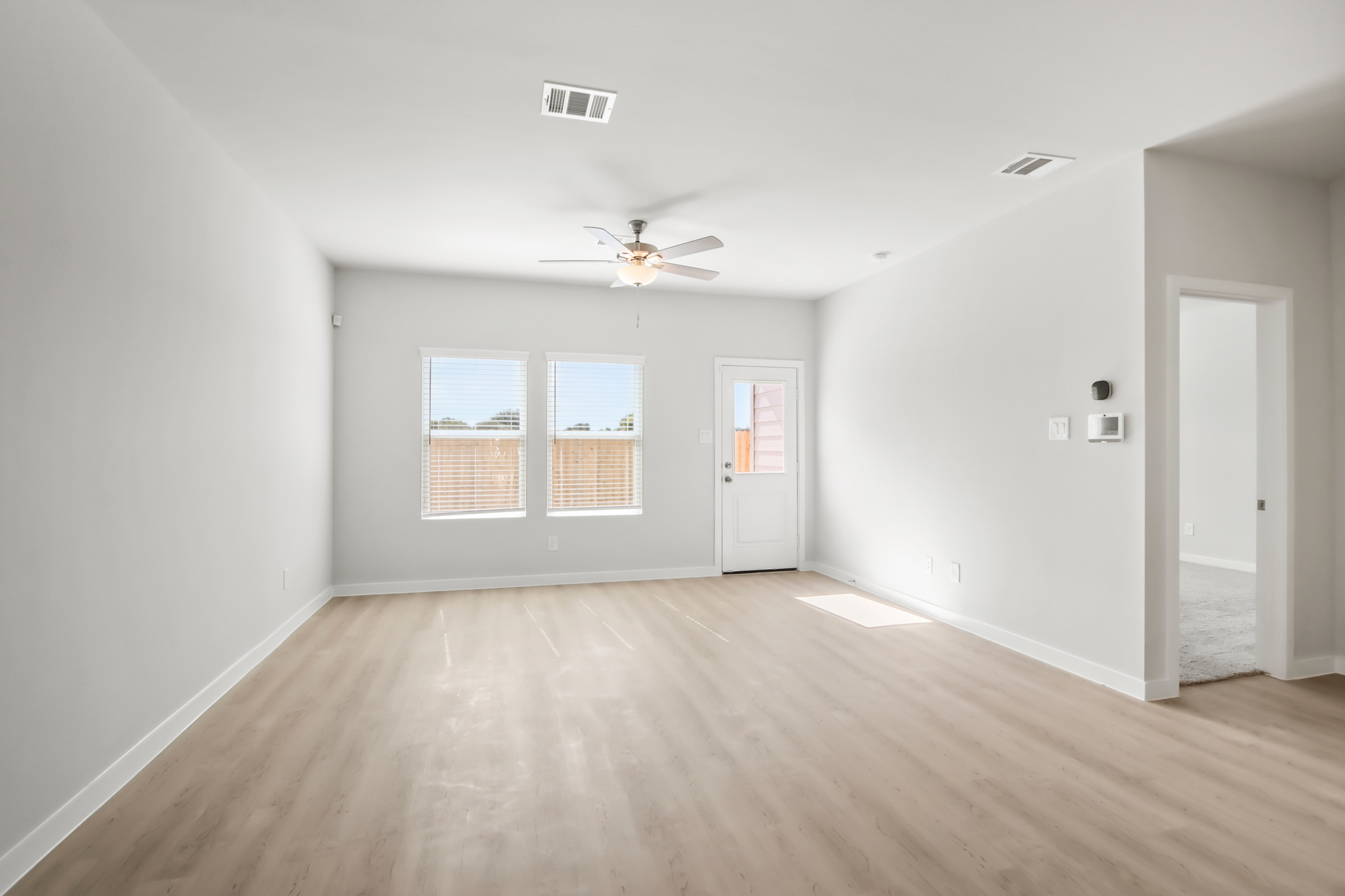 A room with a wood floor and a ceiling fan.