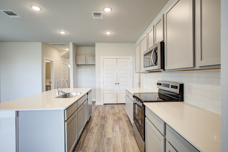 A kitchen with white cabinets.