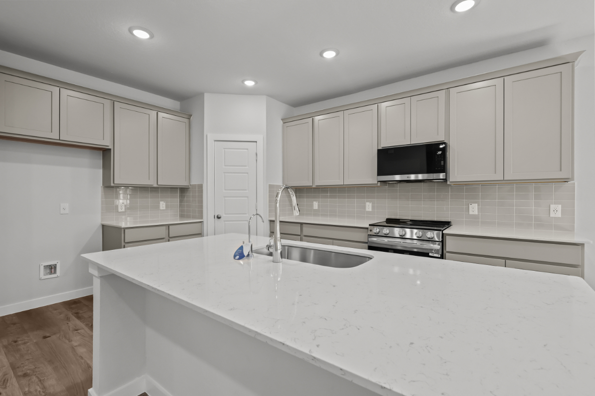 A kitchen with white cabinets.
