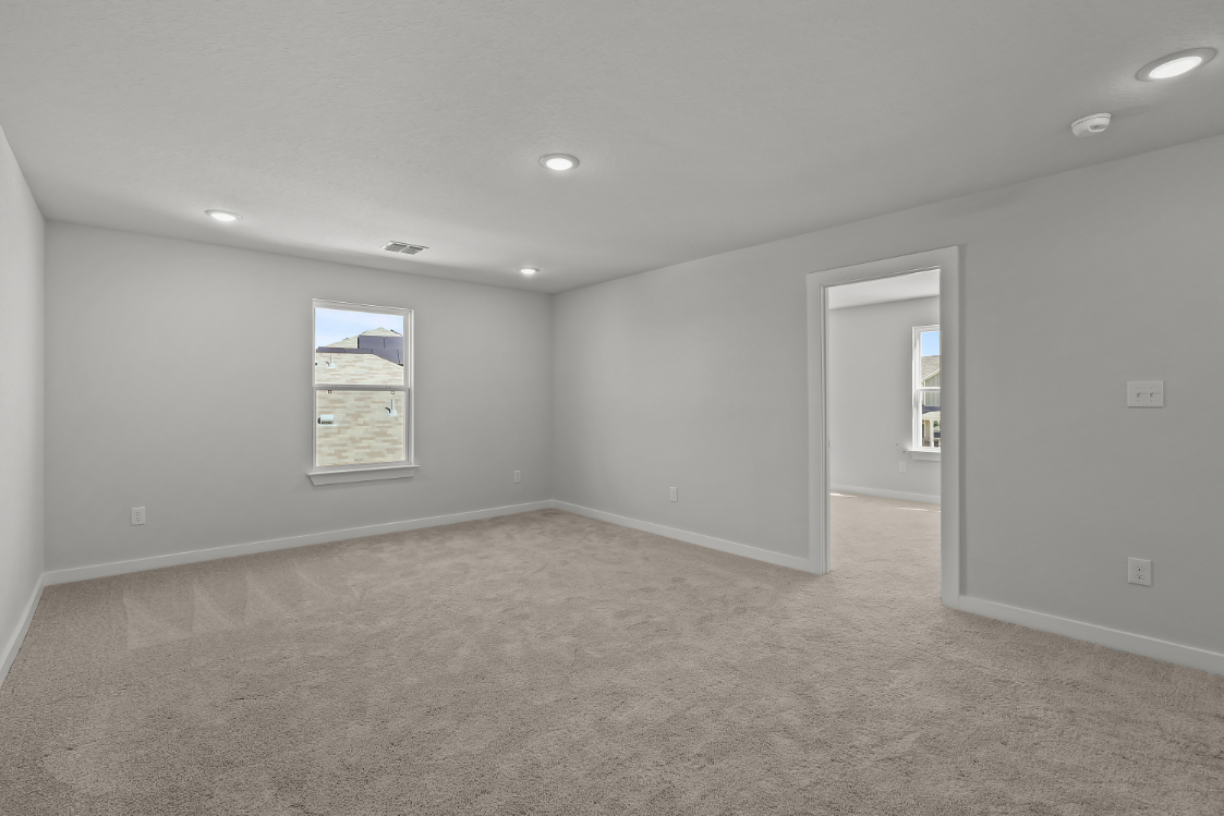 A room with a carpet and a door.