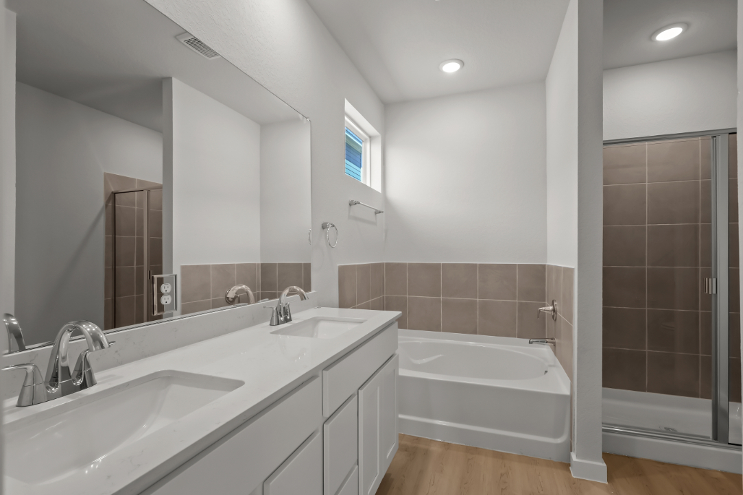 A bathroom with a tub sink and a shower.