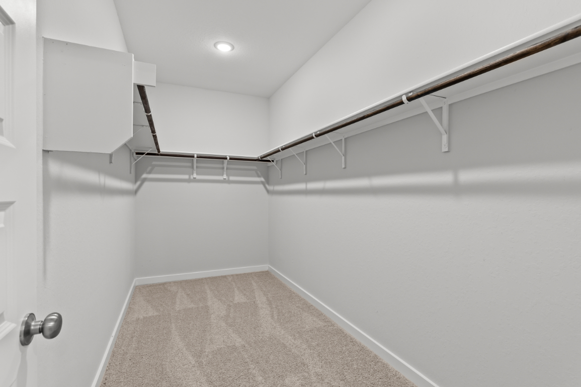 A white hallway with a metal railing.