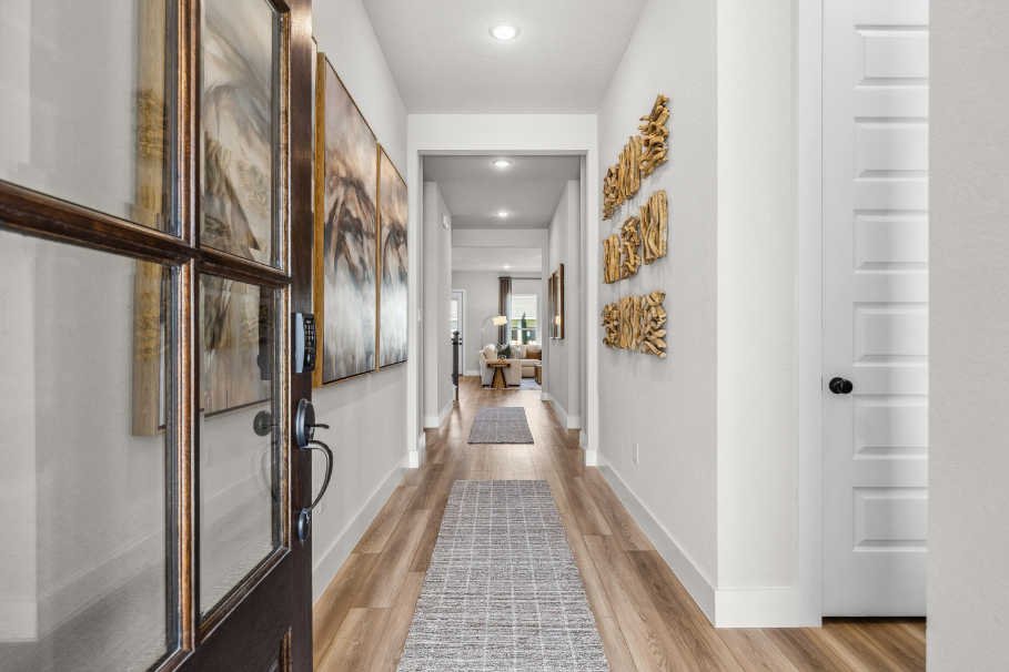 A hallway with a wall of paintings.