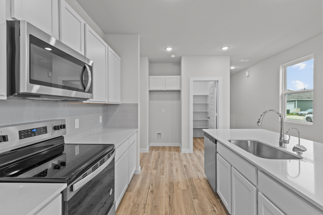 A kitchen with white cabinets.