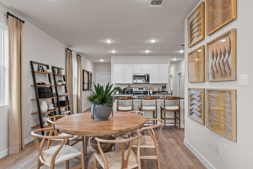 A kitchen with a dining table and chairs.
