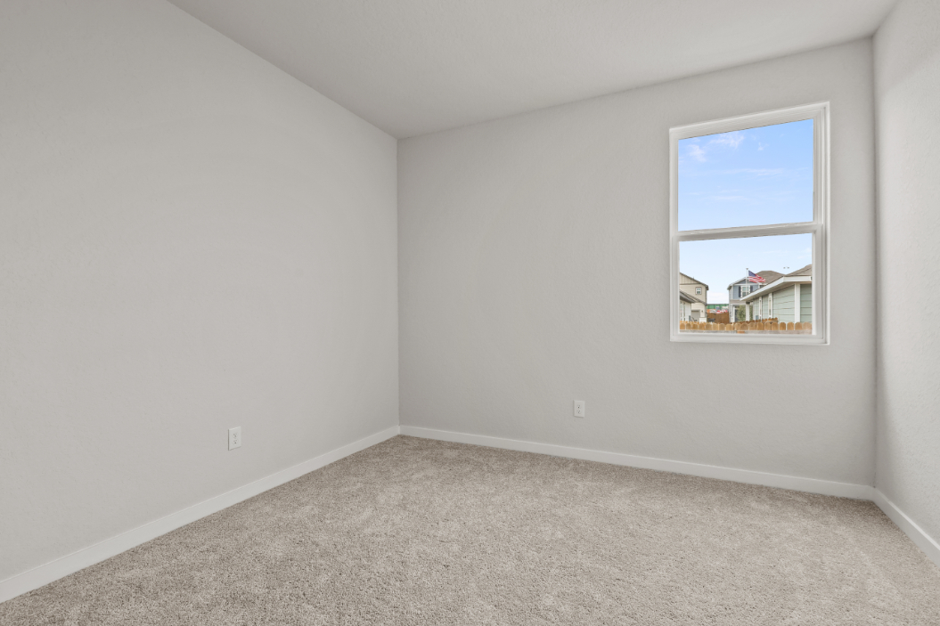 A room with a window and carpet.