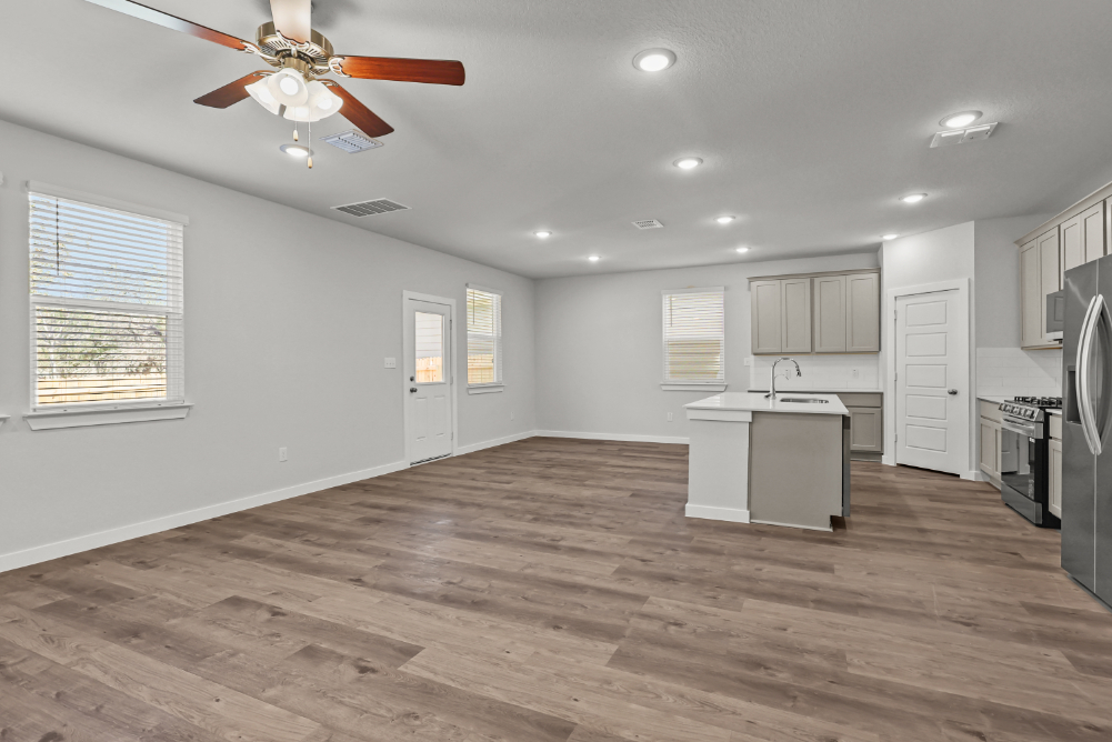 A large kitchen with a wood floor.