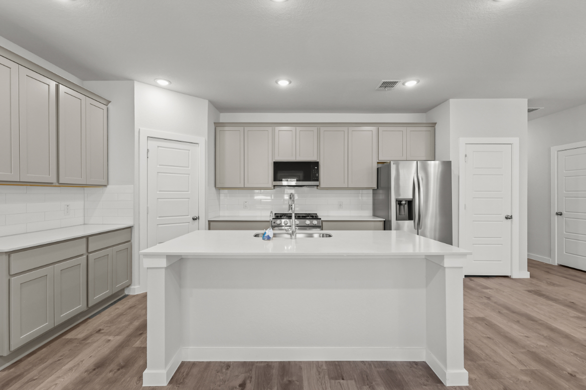 A kitchen with white cabinets.