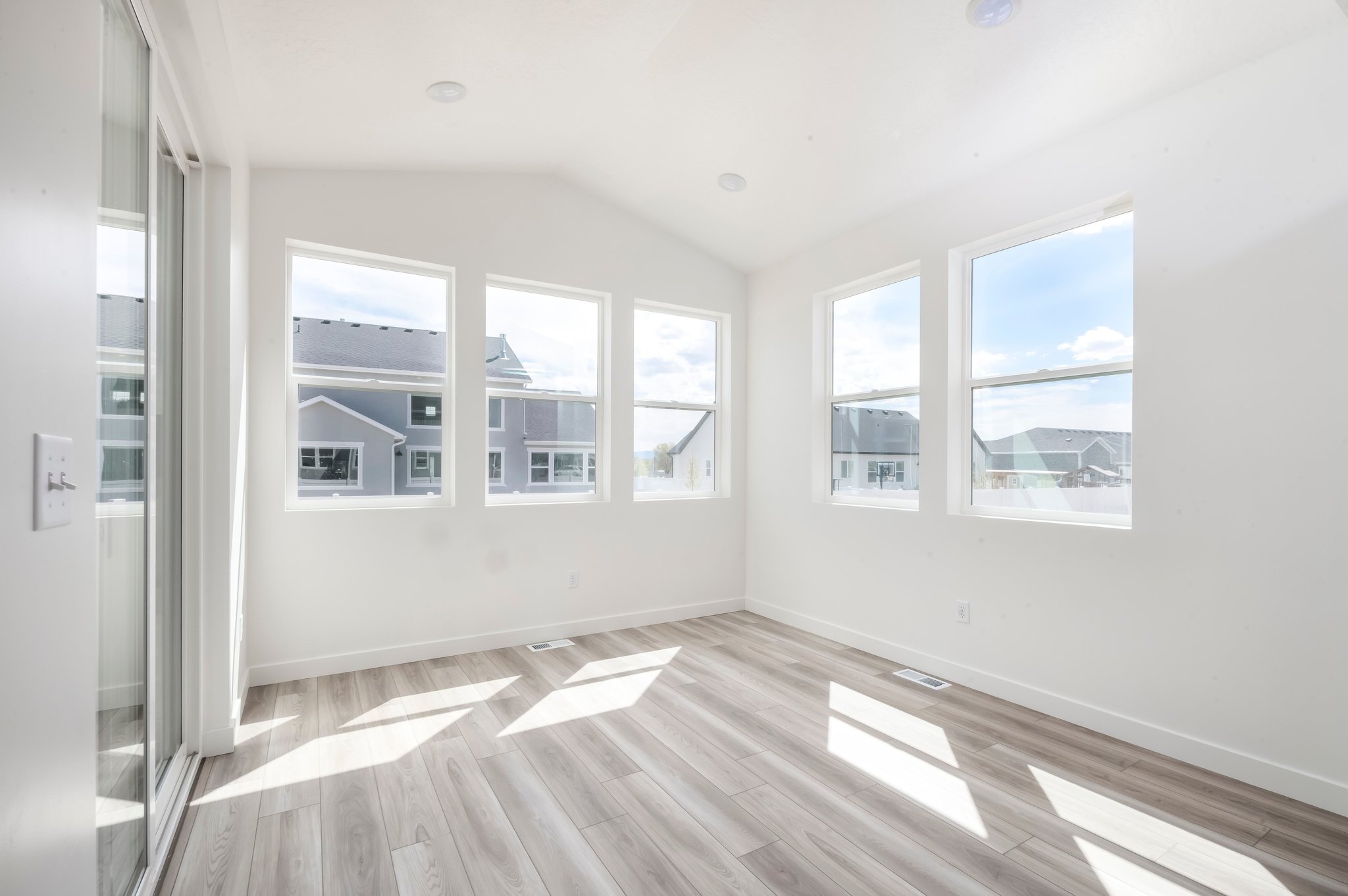A room with windows and a wood floor.