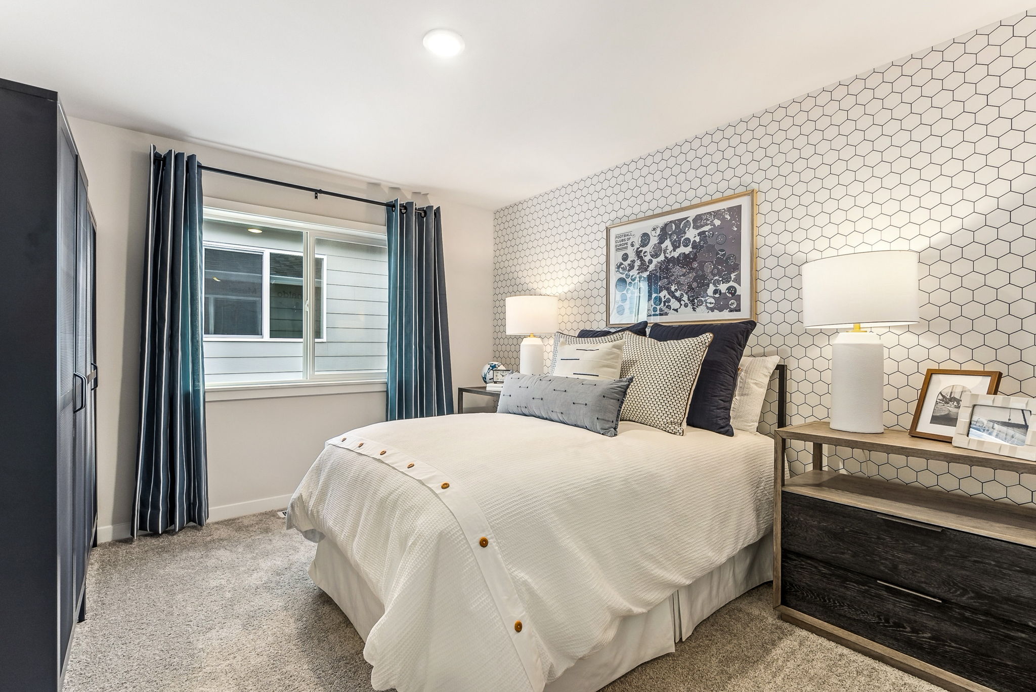 A bedroom with a bed and lamps.