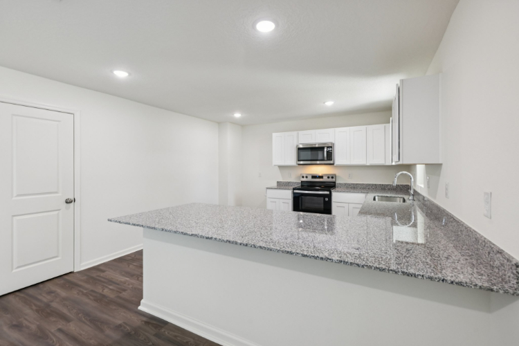A kitchen with marble counters.