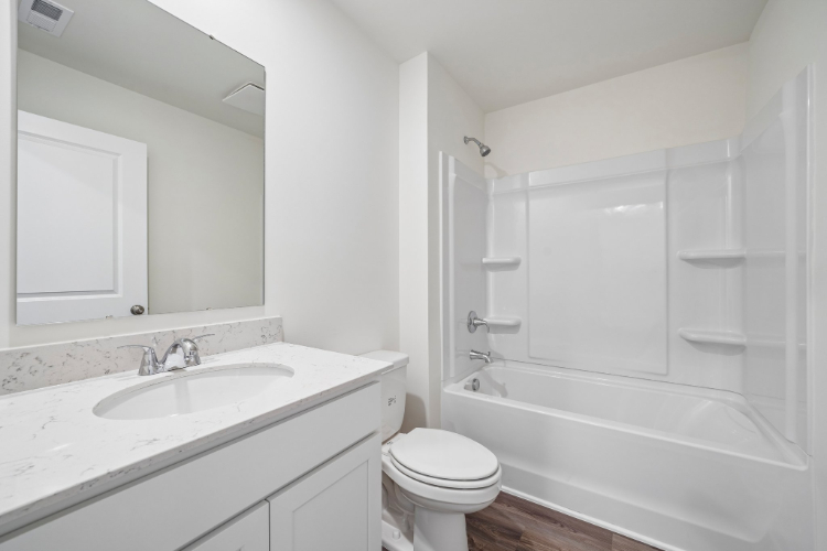 A bathroom with a tub sink and toilet.