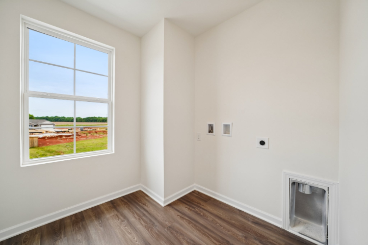 A room with a window and a wood floor.