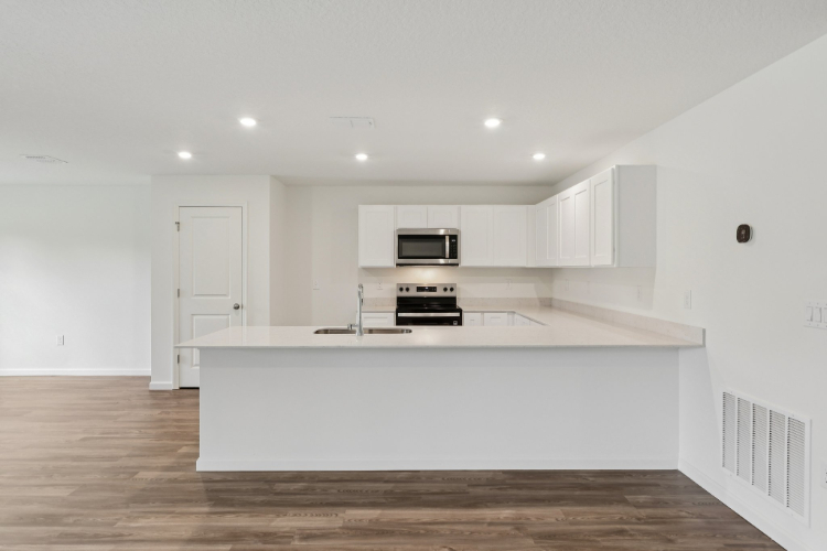 A kitchen with white cabinets.