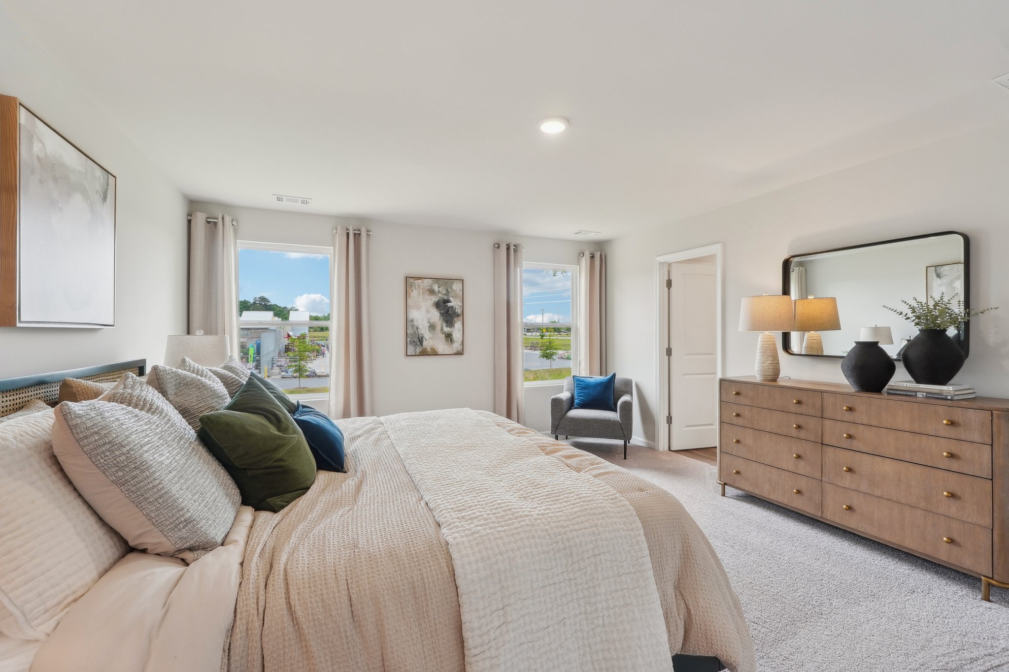 A large bedroom with a bed and a dresser.